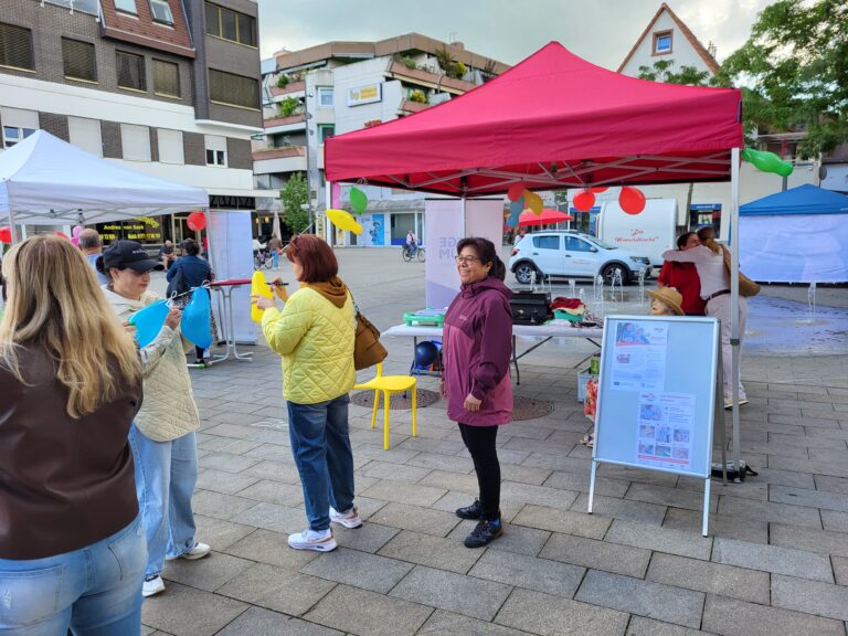 Besucherinnen im Gespräch an den Aktionsständen von Lernmobil auf dem Apostelplatz